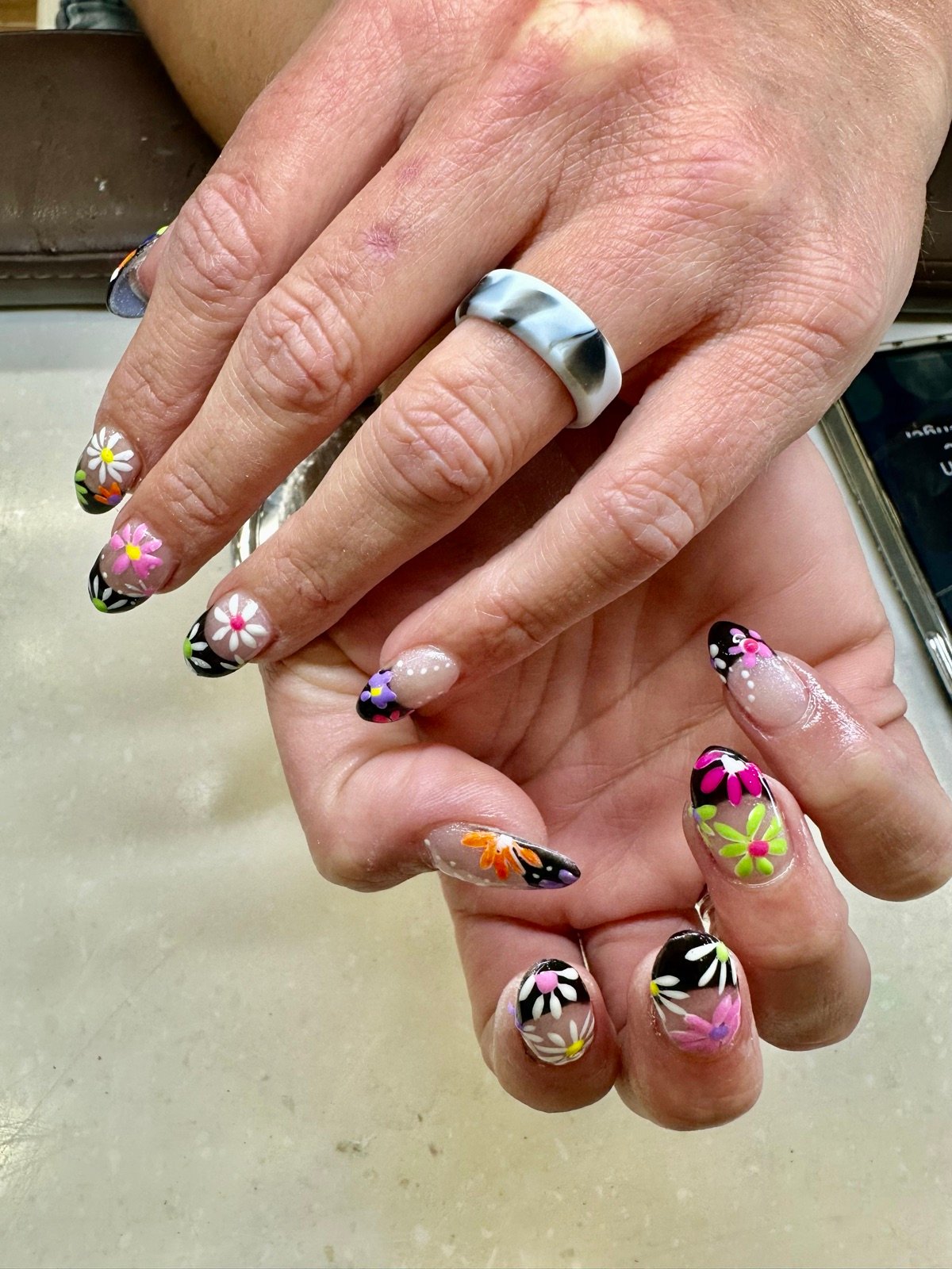 Black accent nails with colorful hand-painted daisy and floral art